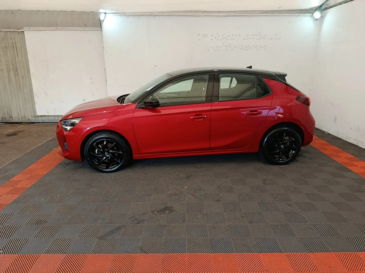Opel Corsa 1.2 Turbo rouge vue de profil côté gauche avec toit noir et jantes noires brillantes.