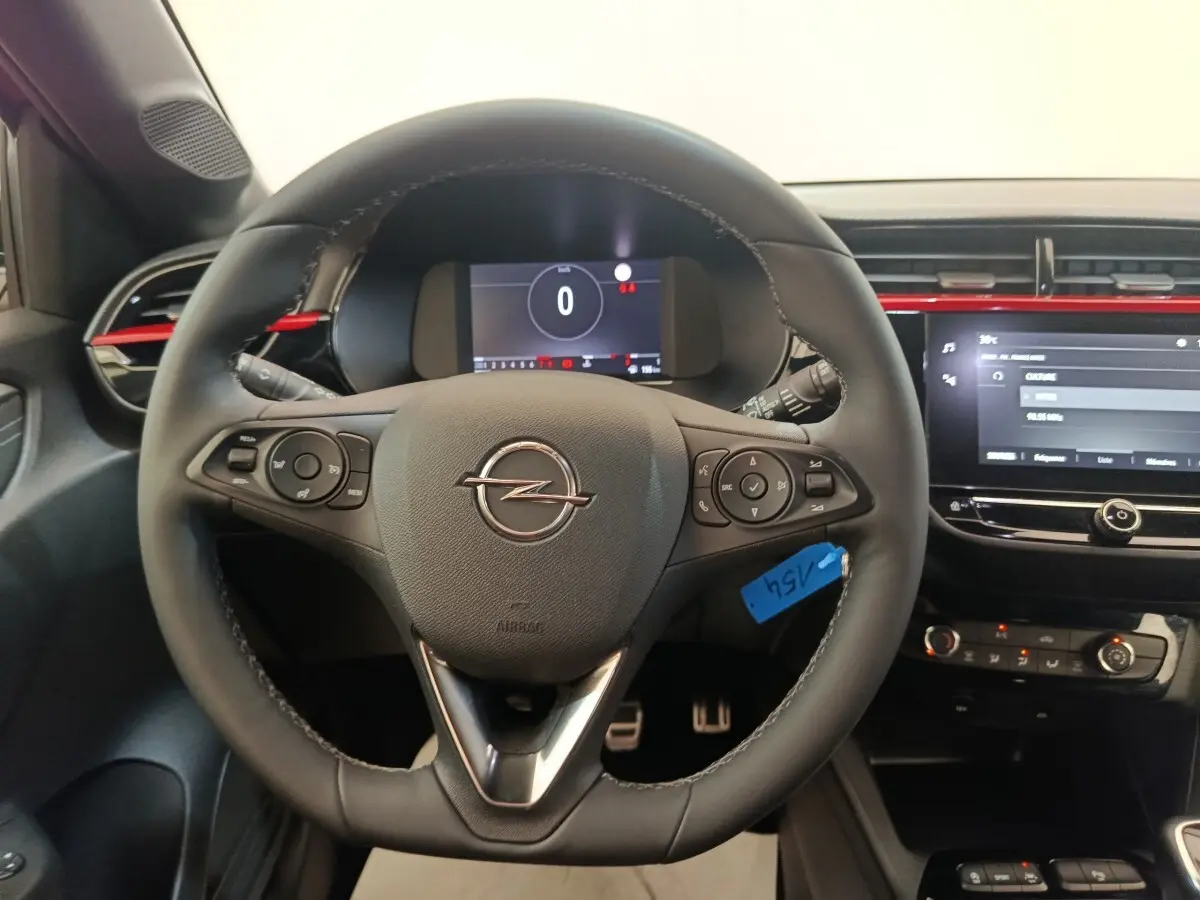 Vue centrée sur le volant cuir de l’Opel Corsa 2023 avec tableau de bord numérique et écran tactile central.