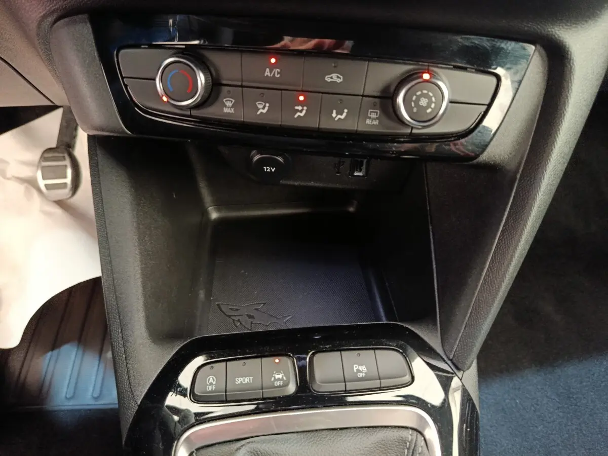 Vue rapprochée de la console centrale noire de l’Opel Corsa 2023, avec commandes climatisation et boutons multifonctions.