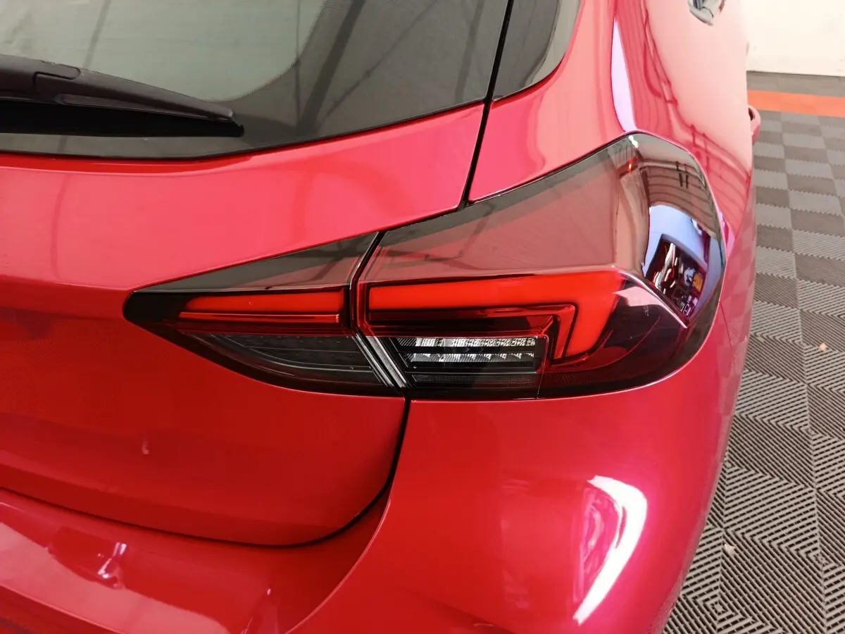 Gros plan sur le feu arrière droit rouge vif d'une Opel Corsa 2023, soulignant les lignes modernes et le vitrage teinté.