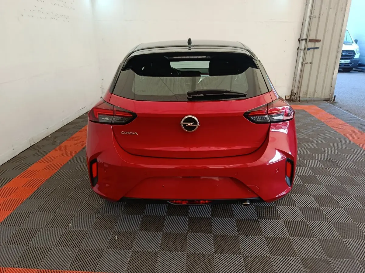 Vue arrière d'une Opel Corsa rouge 2023 avec toit noir, feux arrière LED et logo Opel centré.