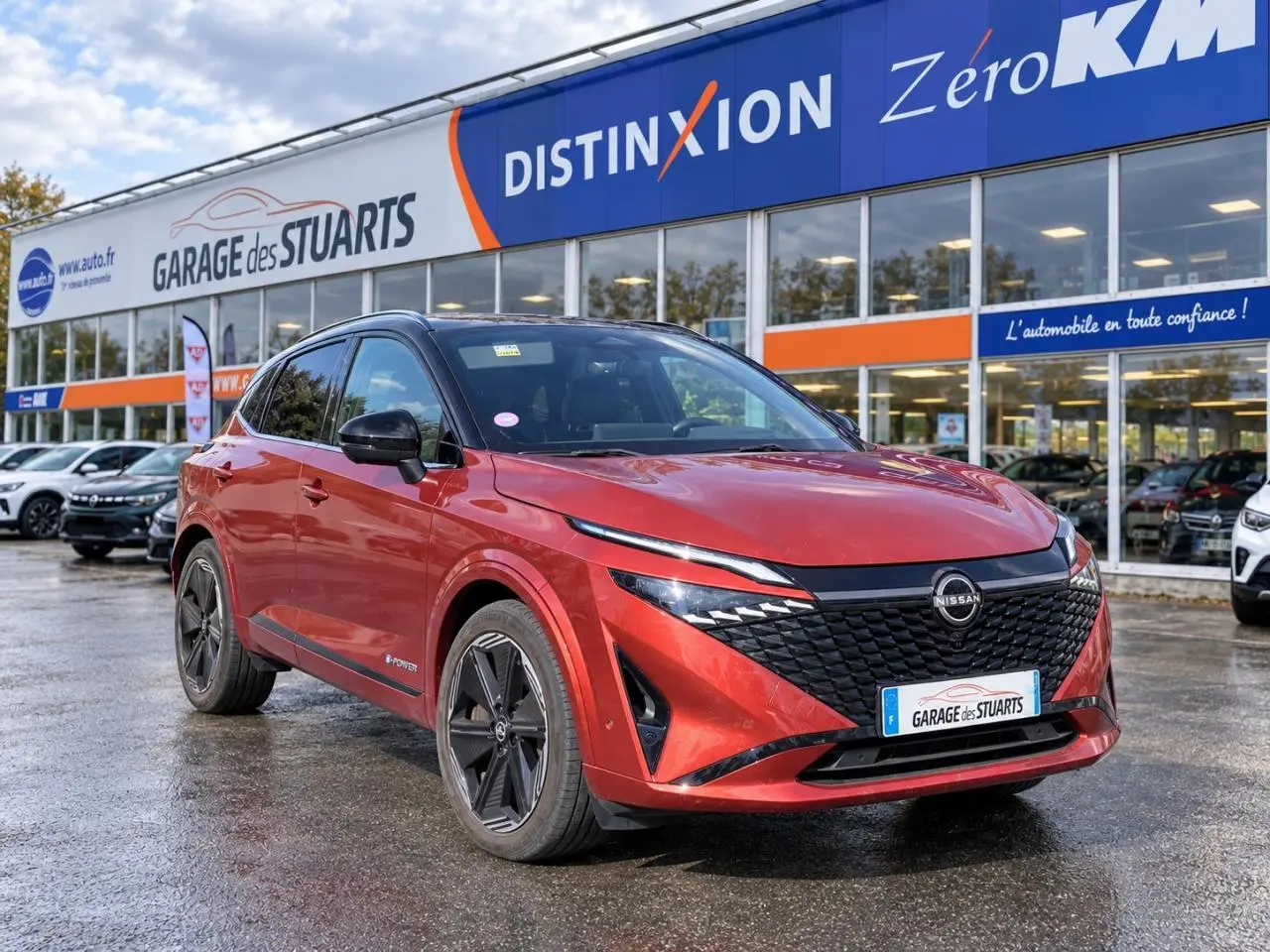 Nissan Qashqai 1.5 e-Power Tekna rouge foncé en 3/4 avant droit, avec calandre noire et jantes noires.