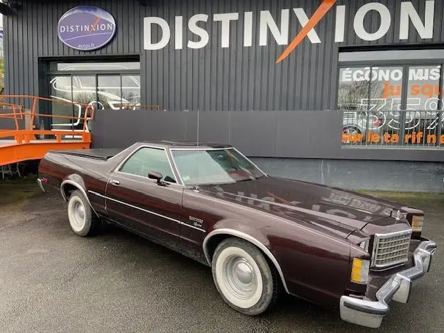 Ford Aerostar Ranchero Squire bordeaux métal en 3/4 avant droit, avec sa carrosserie vintage et jantes argentées.