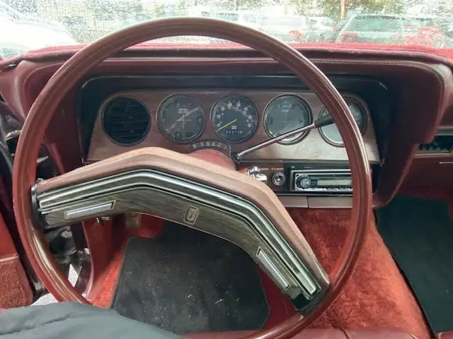 Vue rapprochée du volant bordeaux et du tableau de bord vintage de la Ford Aerostar Ranchero Squire 1979.