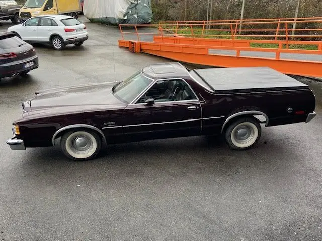 Vue de profil côté gauche d'une Ford Aerostar Ranchero Squire 1979 bordeaux métallisé avec plateau couvert.