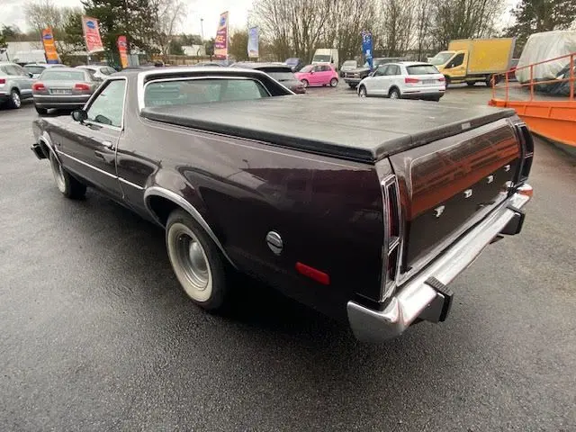 Vue 3/4 arrière droite d'une Ford Aerostar Ranchero Squire 1979 bordeaux métallisé avec benne couverte et jantes d'origine.