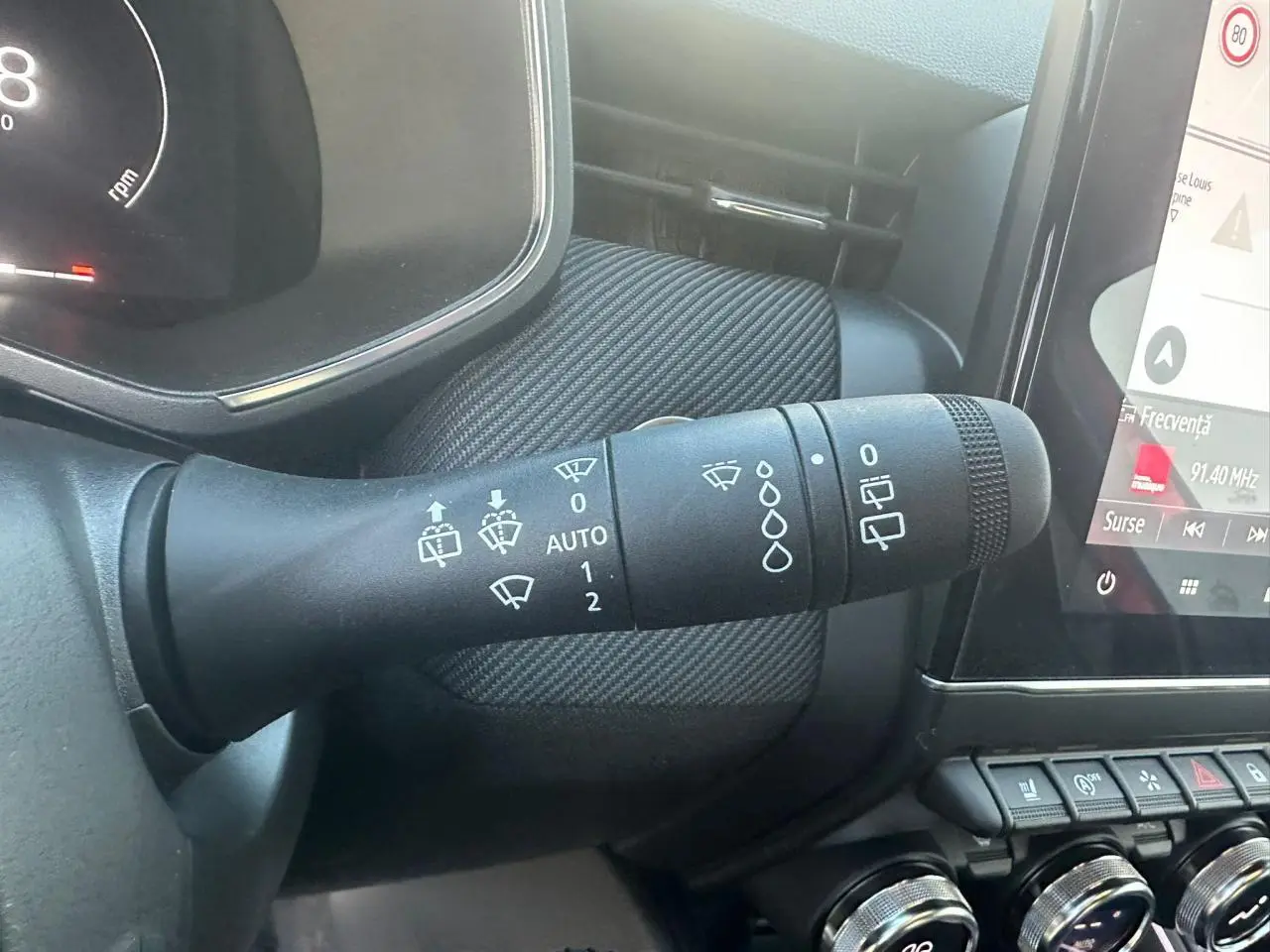 Gros plan sur la commande des essuie-glaces dans l'habitacle noir de la Renault Clio V 2025 finition Esprit Alpine