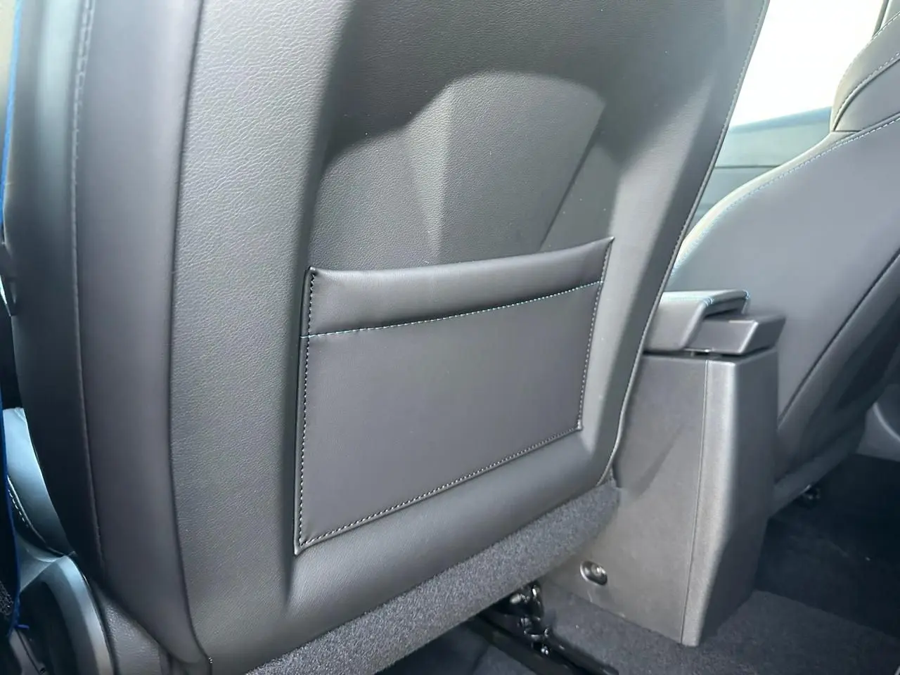 Détail du dossier de siège avant en cuir noir avec surpiqûres bleues dans une Renault Clio V Esprit Alpine 2025.