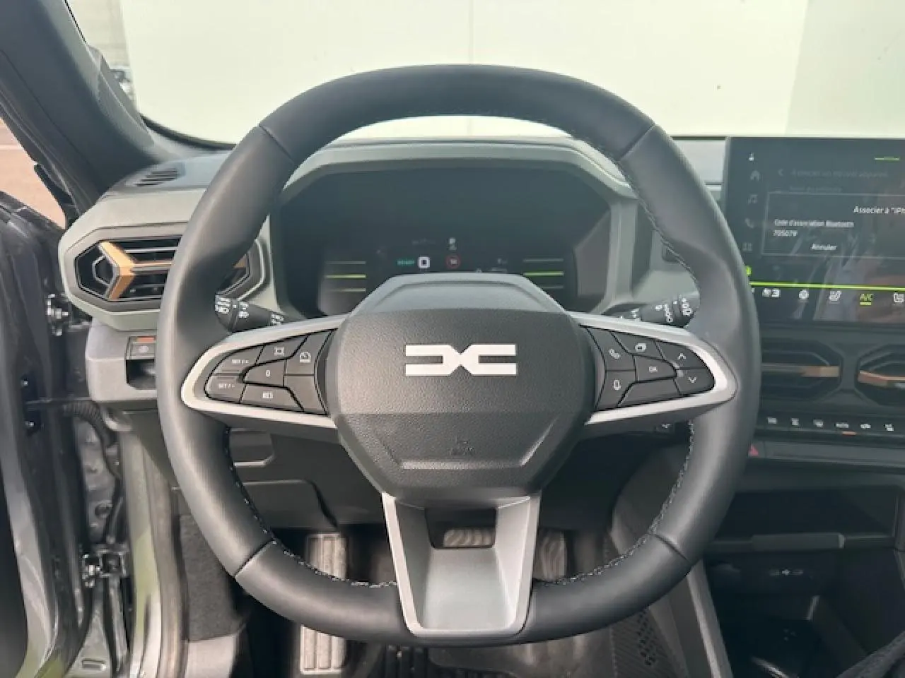 Volant soft feel noir avec commandes intégrées du Dacia Duster III 1.6 Hybrid 140 gris schiste, vue intérieure frontale.