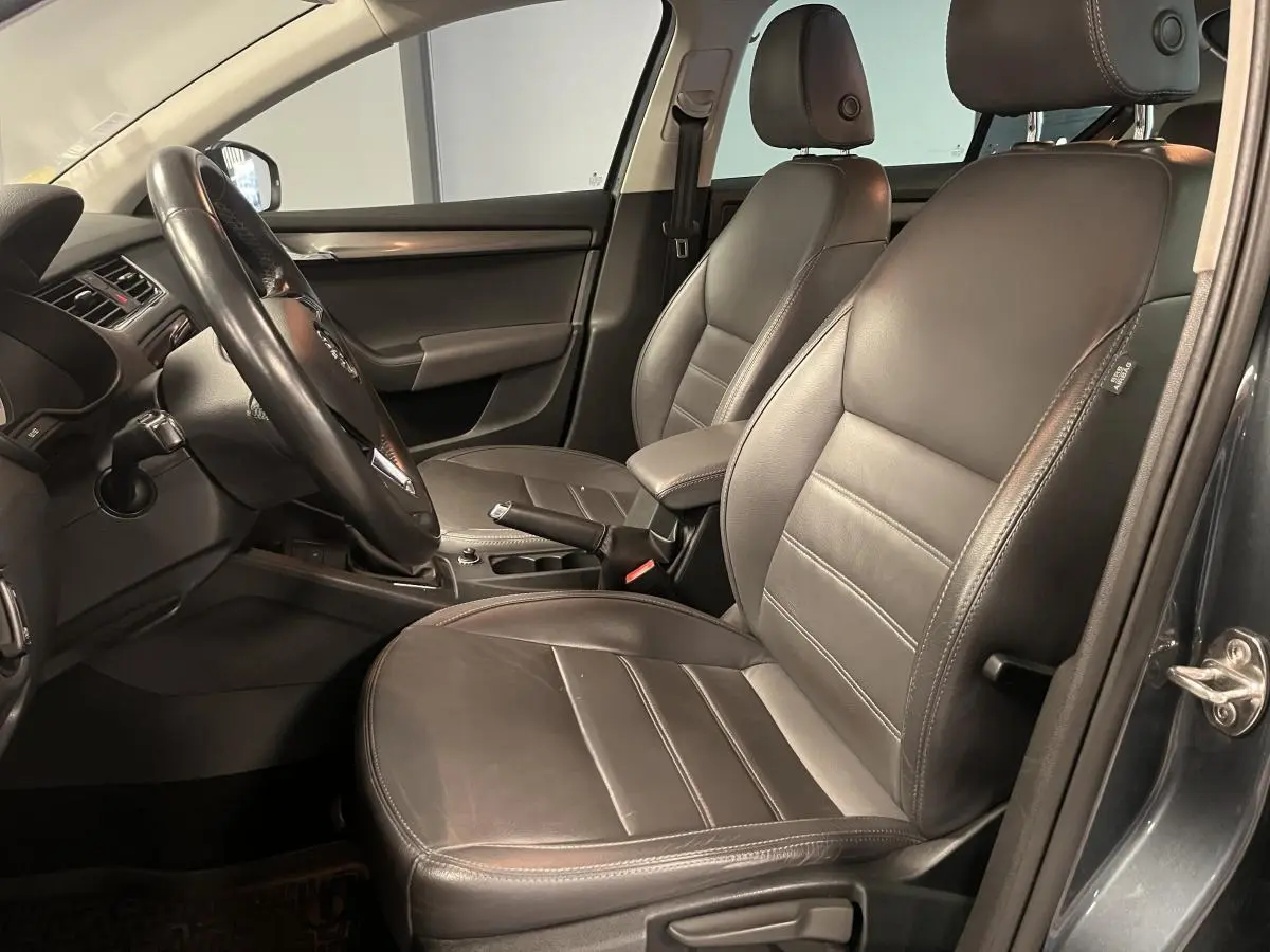 Intérieur cuir noir vu côté conducteur d'une Skoda Octavia 2.0 TDI 2020 avec console centrale et volant visible.