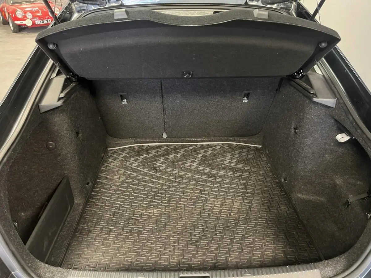 Coffre ouvert vu de face d'une Skoda Octavia gris 2020, avec tapis de sol caoutchouc et fixations ISOFIX.