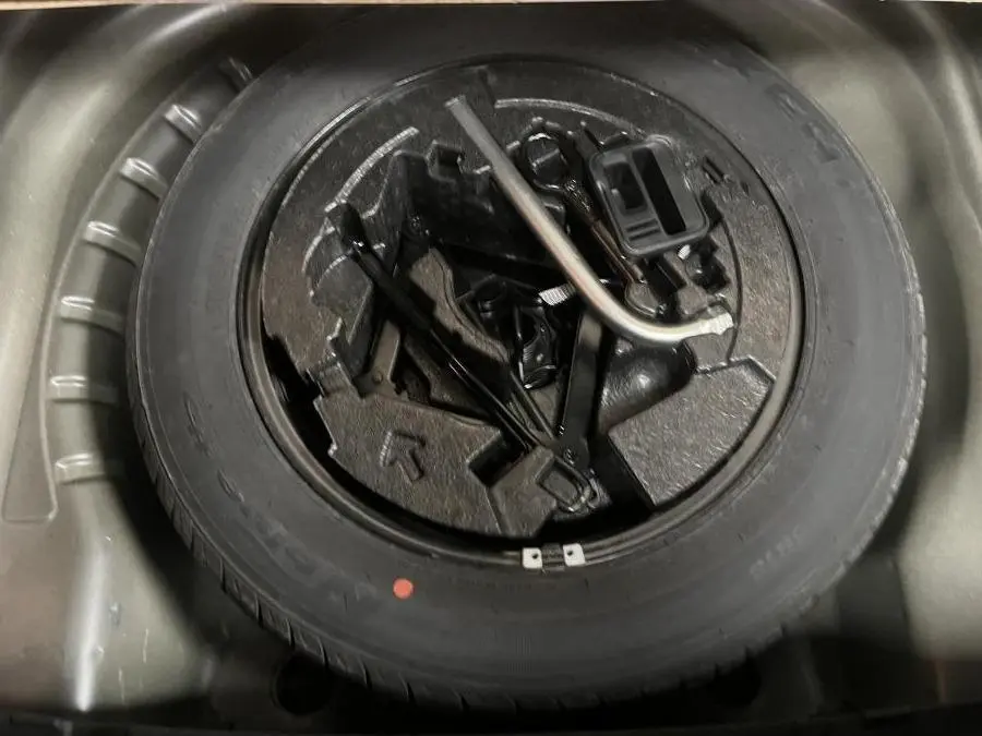 Gros plan sur la roue de secours acier 16 pouces et outils de bord dans le coffre d'une Skoda Octavia gris 2020.