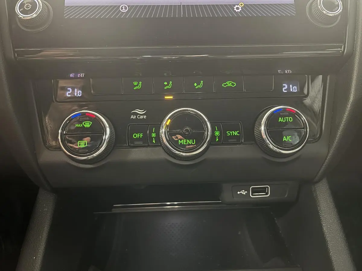 Vue rapprochée de la console centrale noire avec commandes de climatisation automatique bi-zone et port USB d'une Skoda Octavia gris 2020.