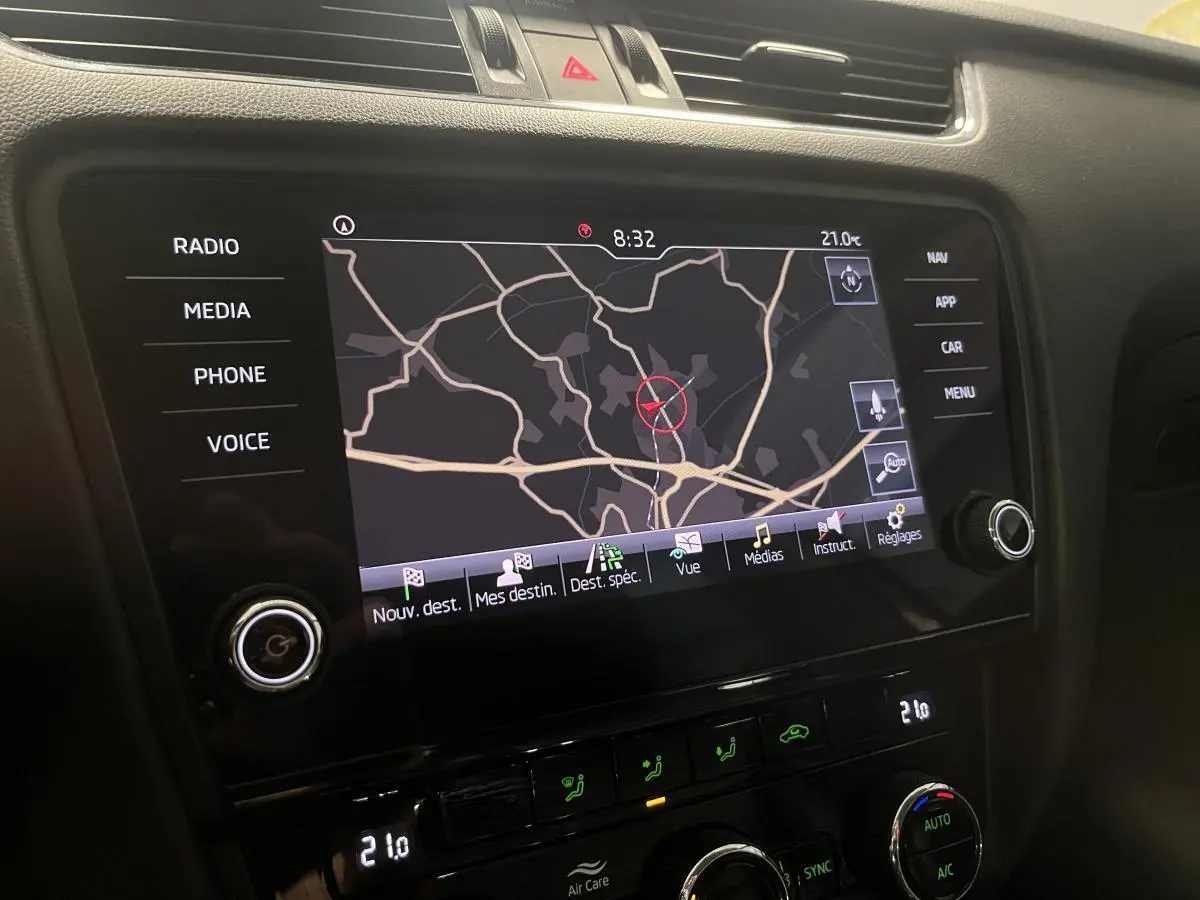 Écran tactile central avec navigation active et commandes climatisation dans une Skoda Octavia gris 2.0 TDI 2020.