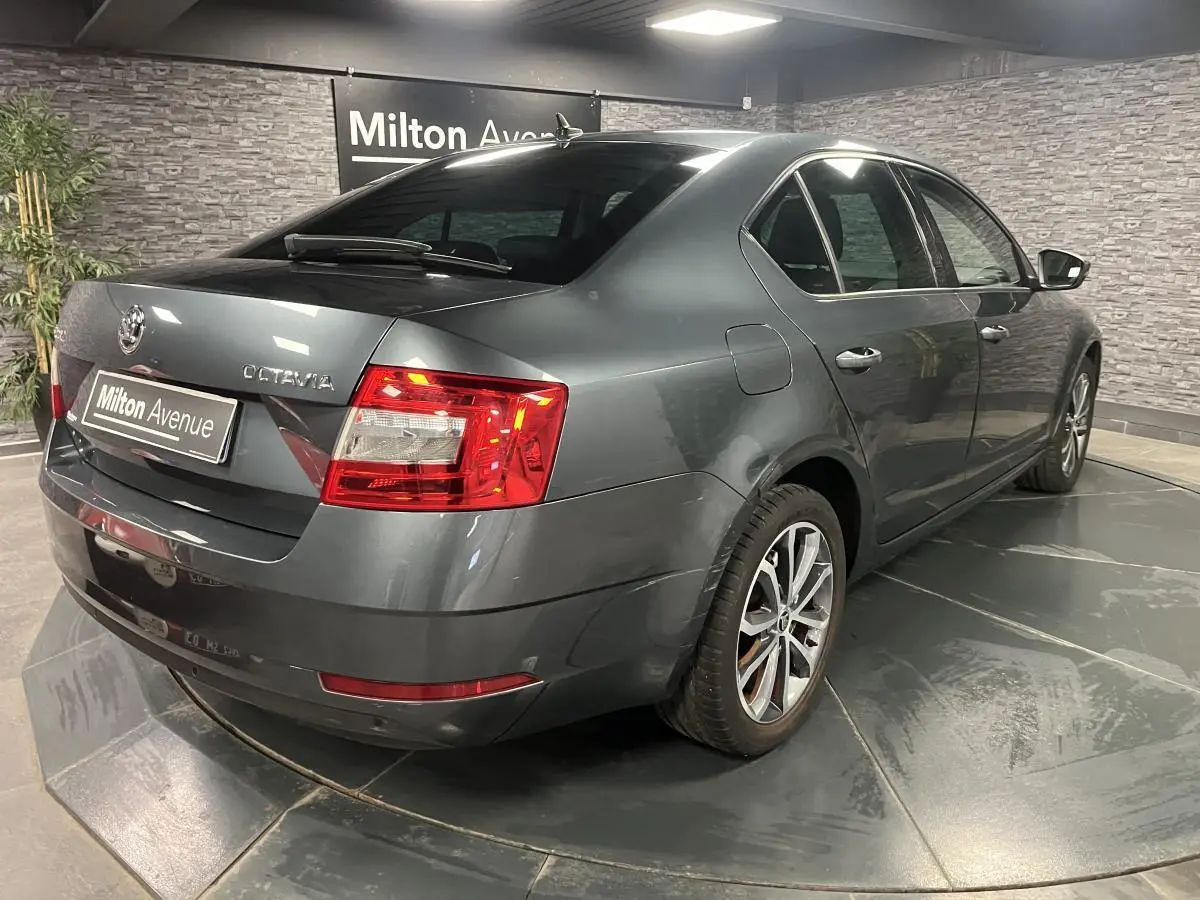 Vue 3/4 arrière droite d'une Skoda Octavia gris métallisé avec feux arrière LED et jantes alliage 17 pouces.