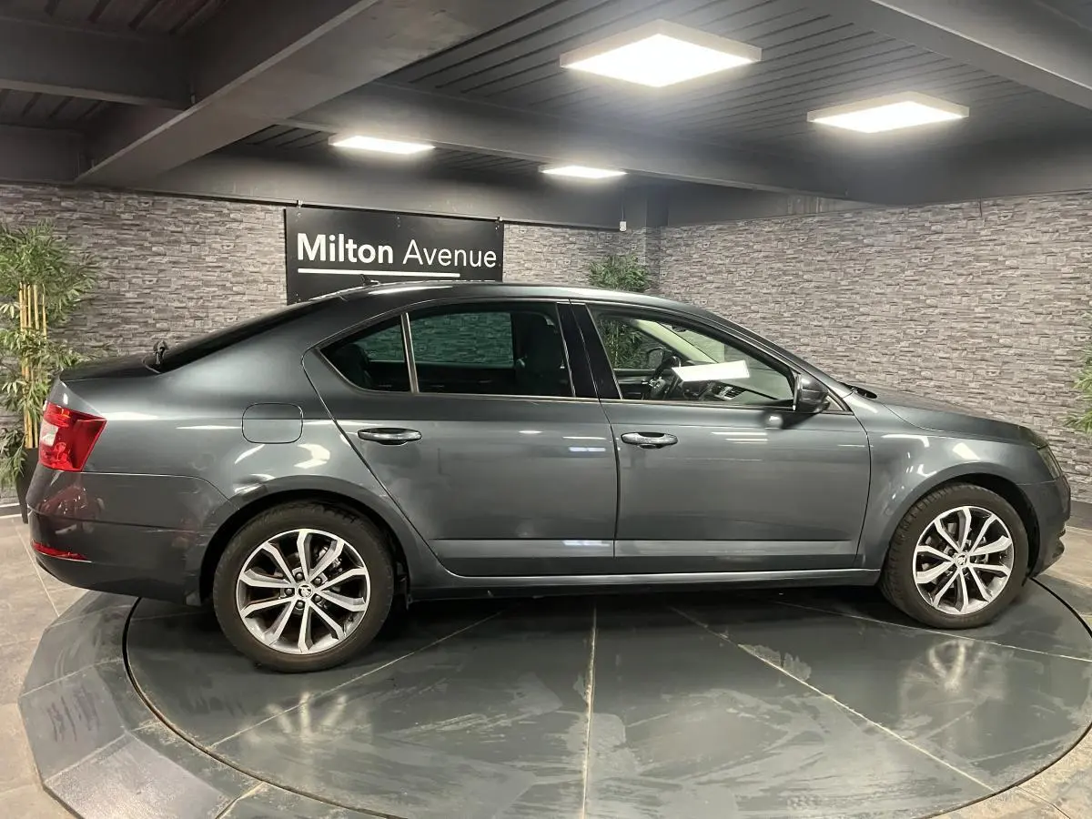 Profil côté gauche d'une Skoda Octavia gris métallisé 2020 avec jantes alliage et poignées couleur carrosserie.