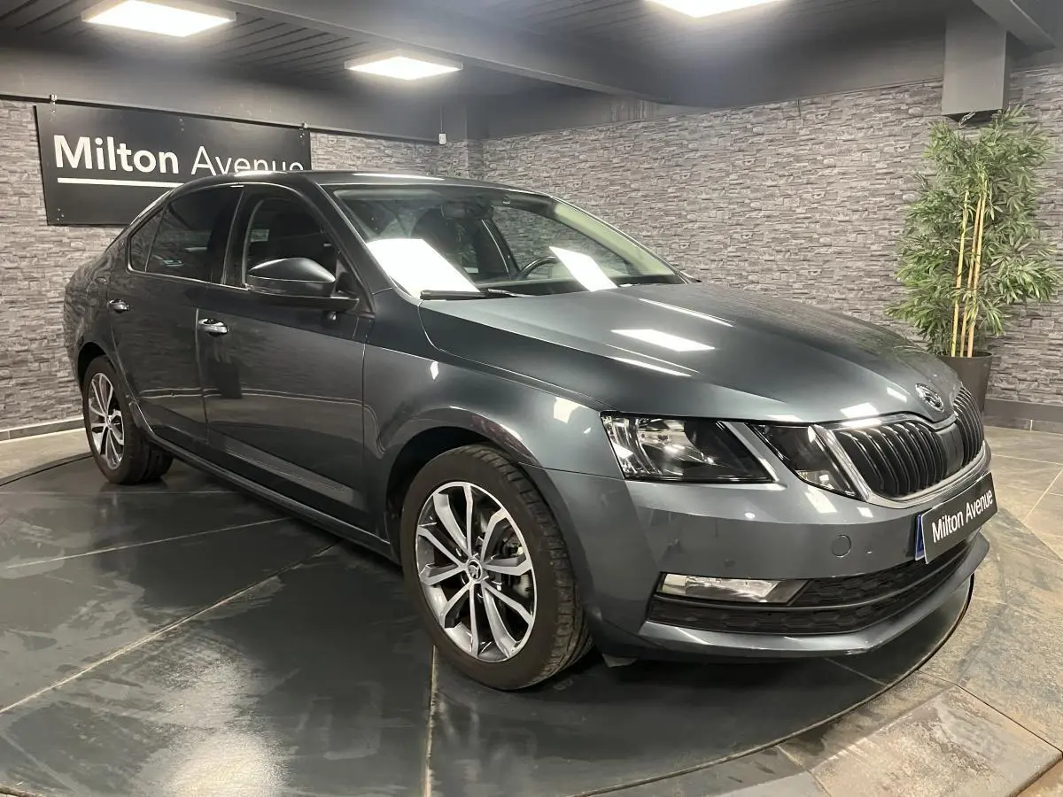 SKODA OCTAVIA gris métallisé vue 3/4 avant droit avec calandre noire et jantes alliage 17 pouces.