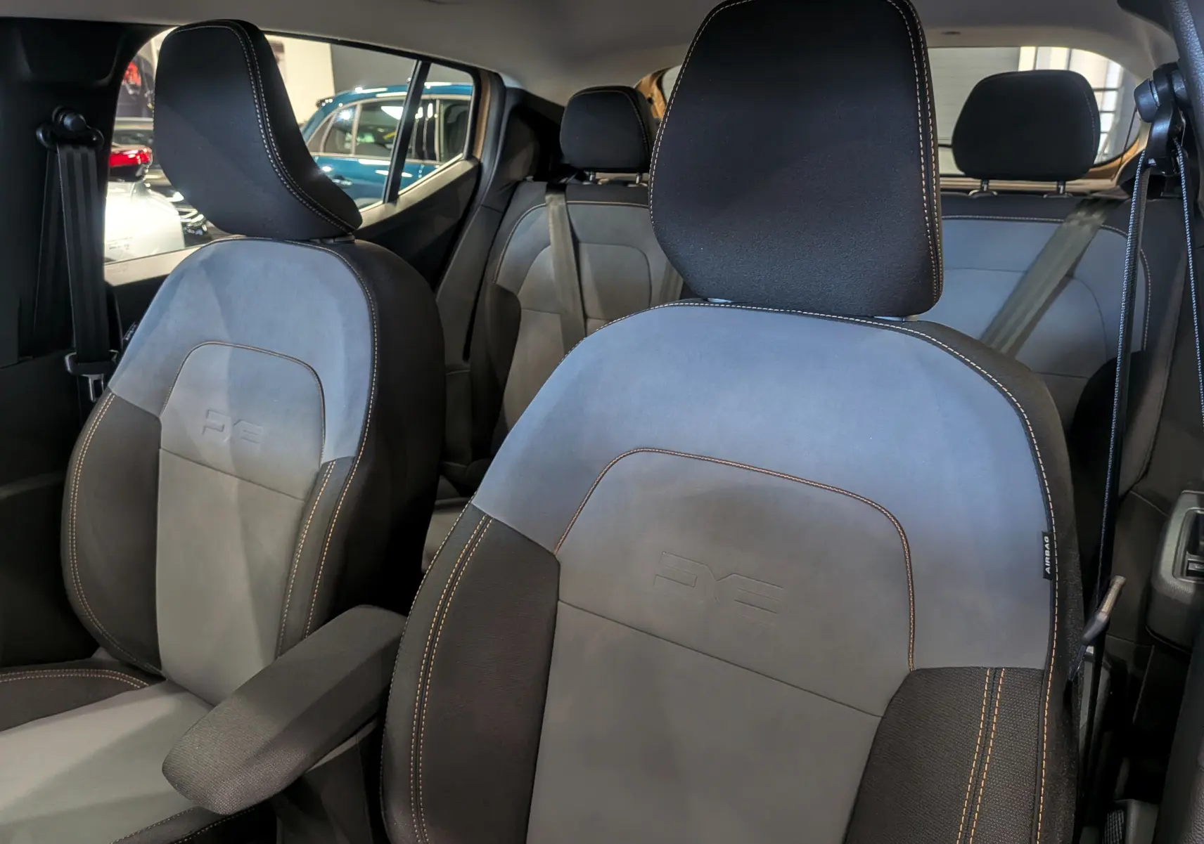 Gros plan sur les sièges avant en tissu gris et noir du Dacia Sandero Stepway 2025, avec surpiqûres contrastées.