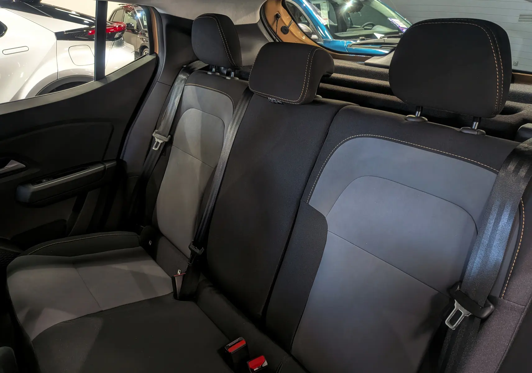 Vue intérieure sur les sièges arrière en tissu noir et gris du Dacia Sandero Stepway 2025, avec ceintures de sécurité visibles.