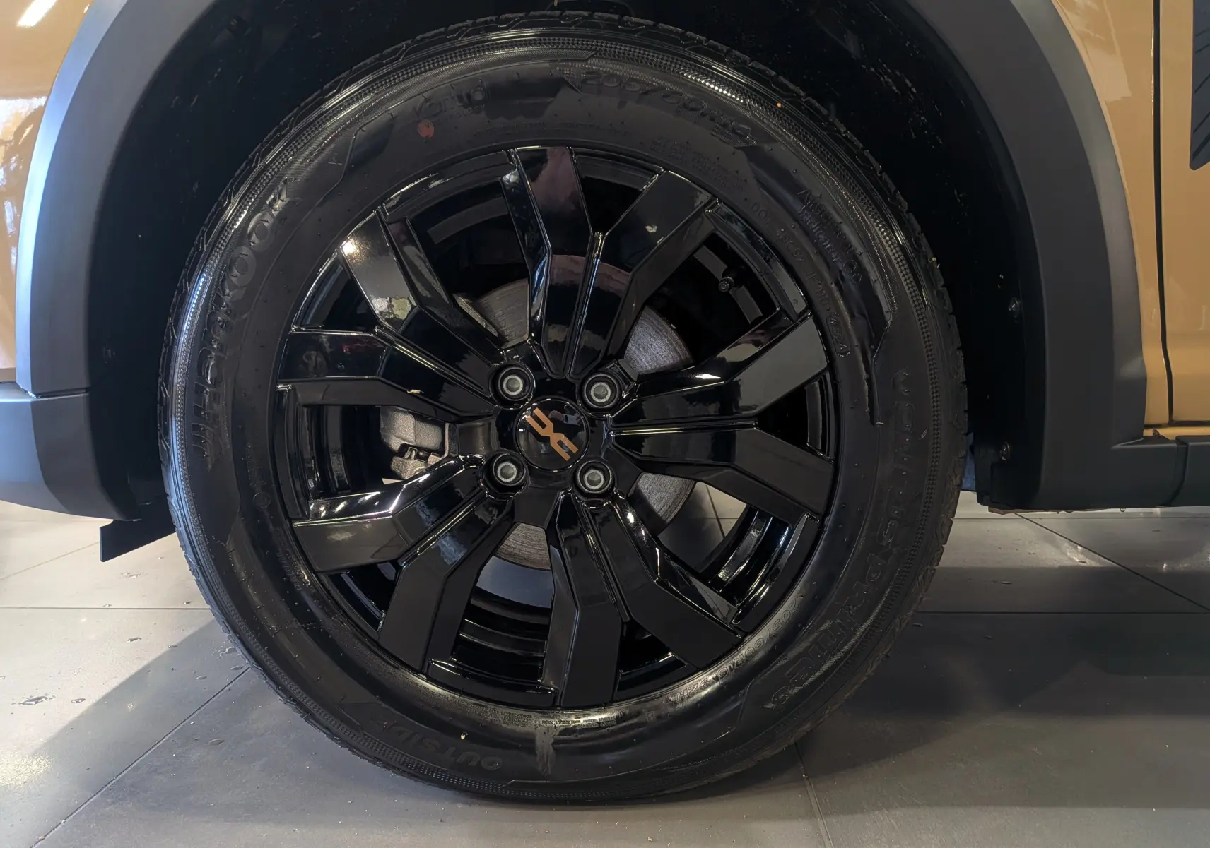 Gros plan sur la roue avant droite noire brillante d'une Dacia Sandero Stepway Beige Safari 2025.