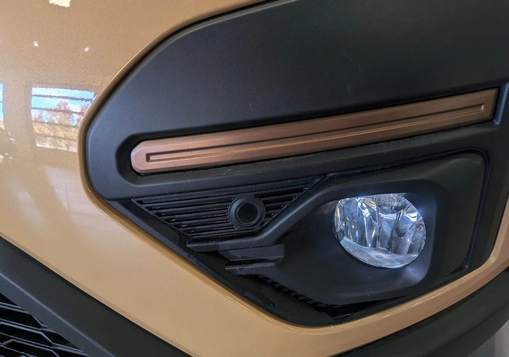 Gros plan sur le feu antibrouillard avant droit beige Safari du Dacia Sandero Stepway TCe 110 CH EXTREME 2025.