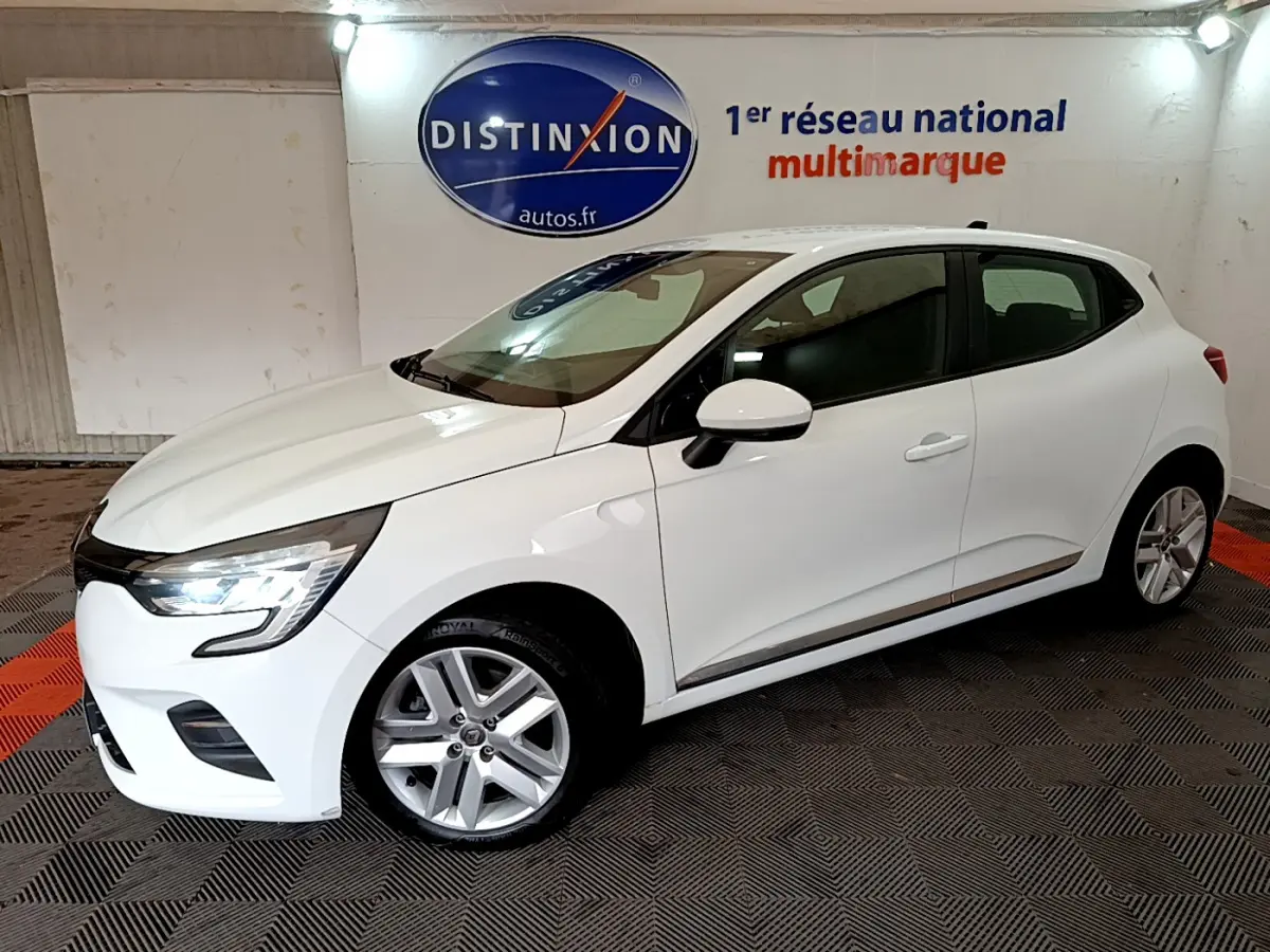 Renault Clio Business Blue dCi 85 blanc vue de profil côté gauche dans un showroom avec logo Distinxion en arrière-plan.