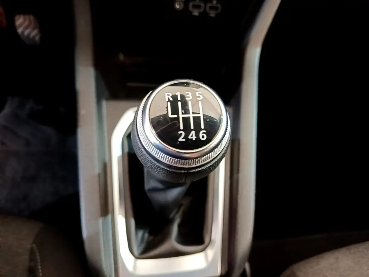 Le levier de vitesses manuel noir de la Renault Clio Business Blue dCi 85, vu de dessus, avec marquage des rapports blancs.