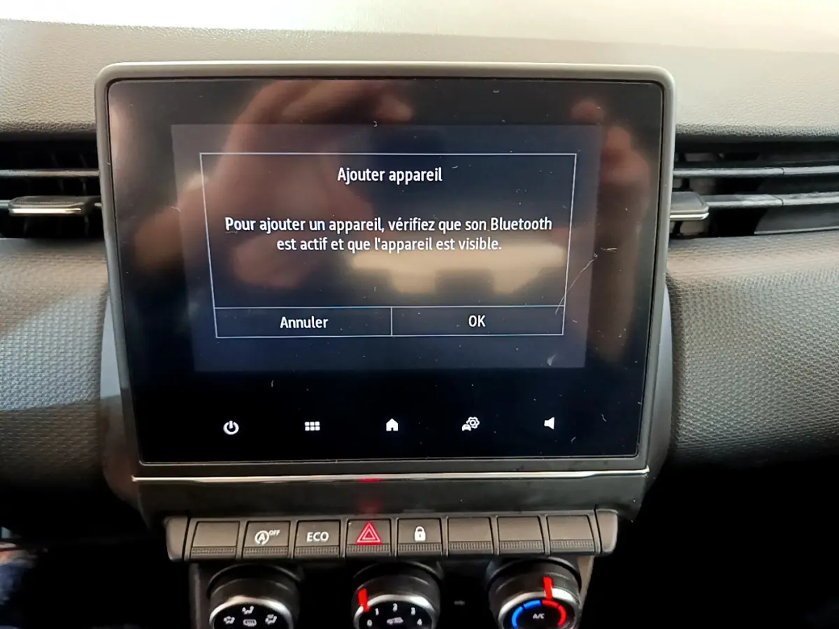 Écran tactile central affichant l'ajout d'appareil Bluetooth dans le tableau de bord noir d'une Renault Clio Business 2020.