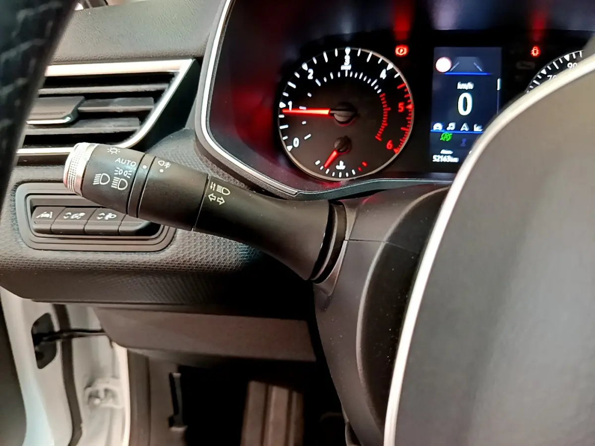 Gros plan sur le combiné d'instruments et la commande de phares d'une Renault Clio Business Blue dCi 85 blanche de 2020.