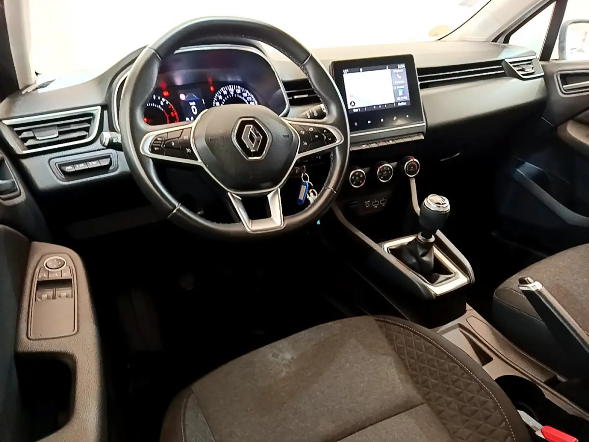 Intérieur de Renault Clio Business 2020, vue côté conducteur, volant cuir, écran tactile et boîte manuelle visibles.