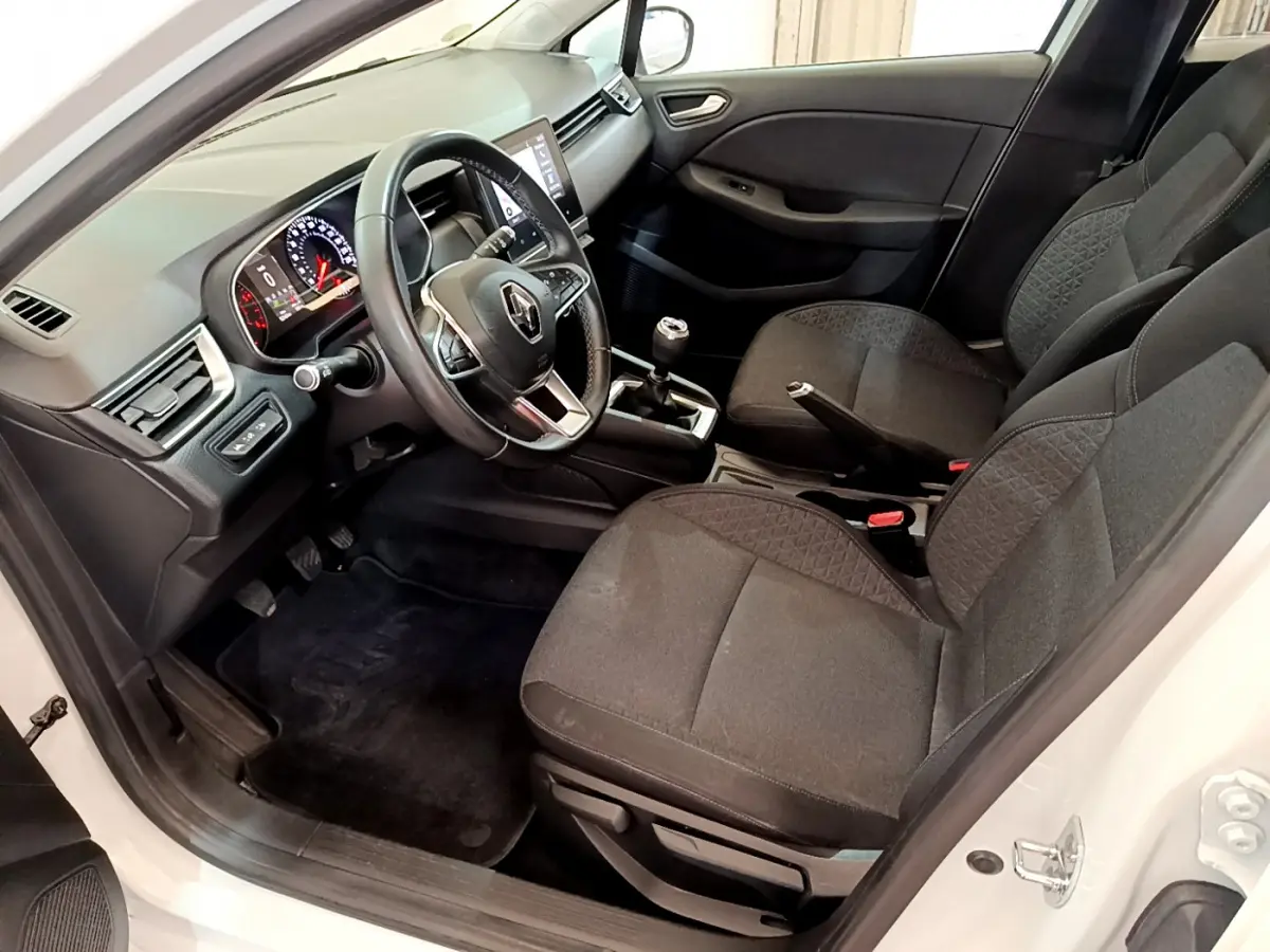 Intérieur côté conducteur d'une Renault Clio Business Blue dCi 85 blanche, avec tableau de bord numérique et volant multifonctions cuir.