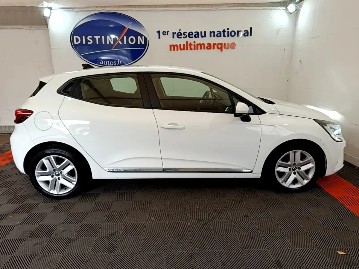 Profil côté droit d'une Renault Clio Business Blue dCi 85 blanche, avec jantes alliage et feux arrière LED visibles.