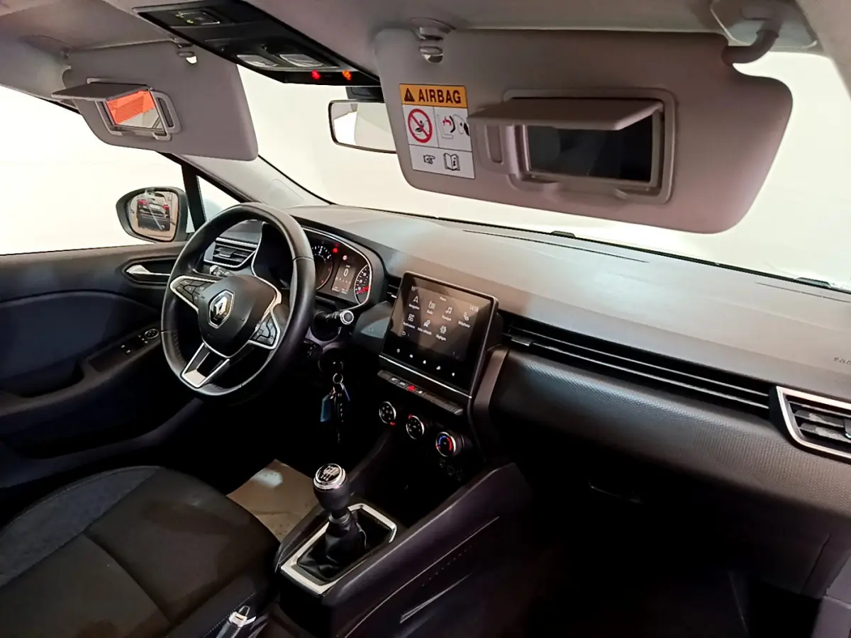 Intérieur avant droit de la Renault Clio Business Blue dCi 85 2020, volant cuir, écran tactile et boîte manuelle visibles.