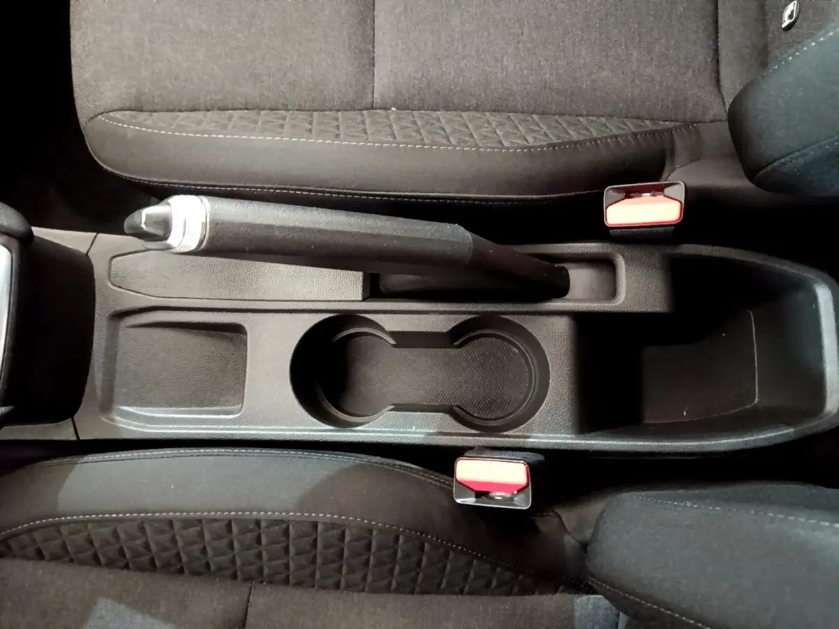 Vue plongeante sur la console centrale noire avec frein à main et porte-gobelets de la Renault Clio Business 2020.