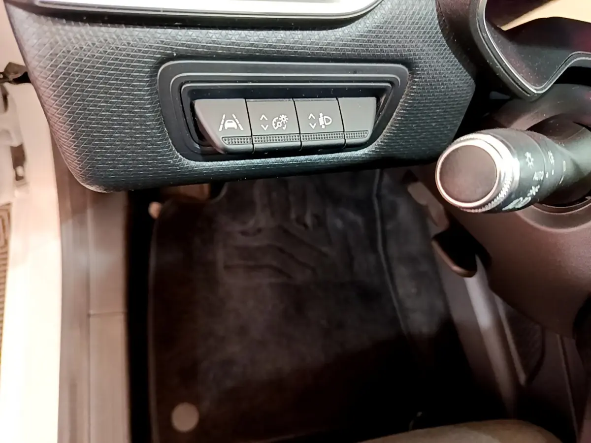 Vue intérieure rapprochée côté gauche du tableau de bord noir avec commandes d'assistance sur Renault Clio blanche 2020.