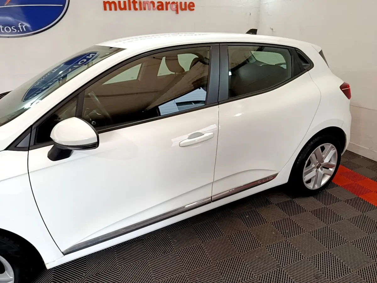 Profil côté gauche de la Renault Clio Business Blue dCi 85 blanche, avec jantes alliage et rétroviseur blanc.