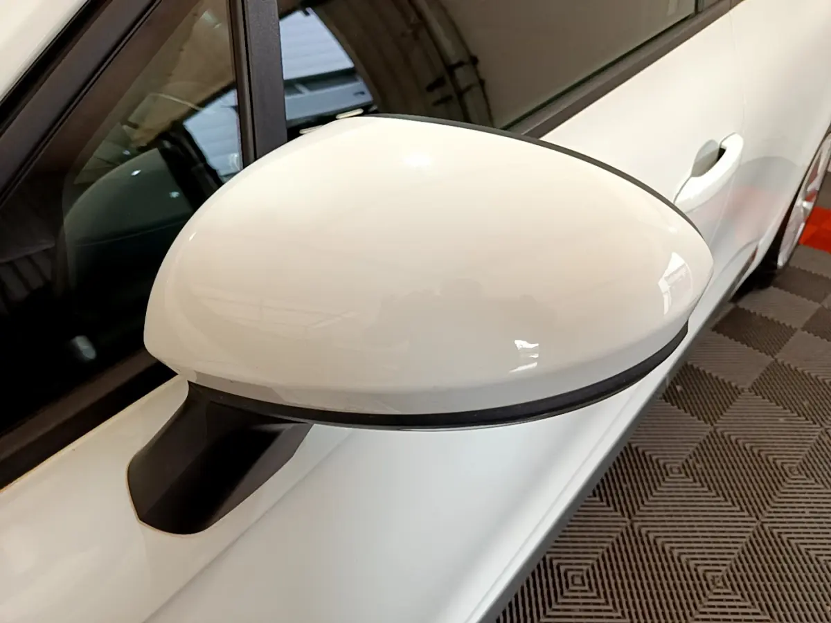 Rétroviseur blanc côté gauche d'une Renault Clio Business 2020 vue en gros plan sur fond intérieur.