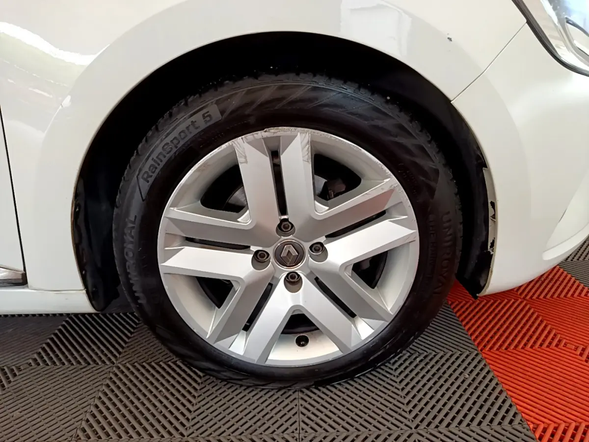 Gros plan sur la roue avant gauche blanche d'une Renault Clio Business Blue dCi 85 avec jante alliage distinctive.