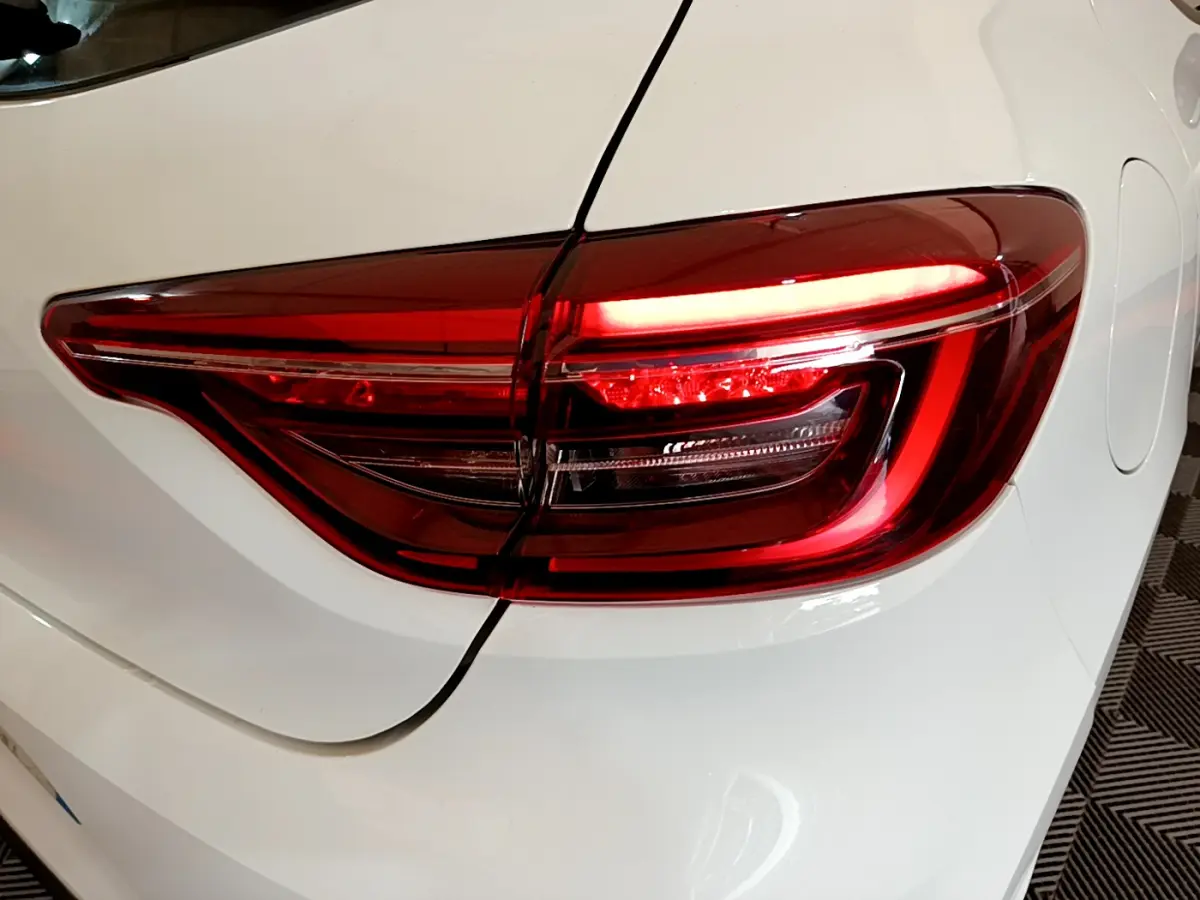 Gros plan sur le feu arrière droit rouge d’une Renault Clio Business Blue dCi 85 blanche de 2020.