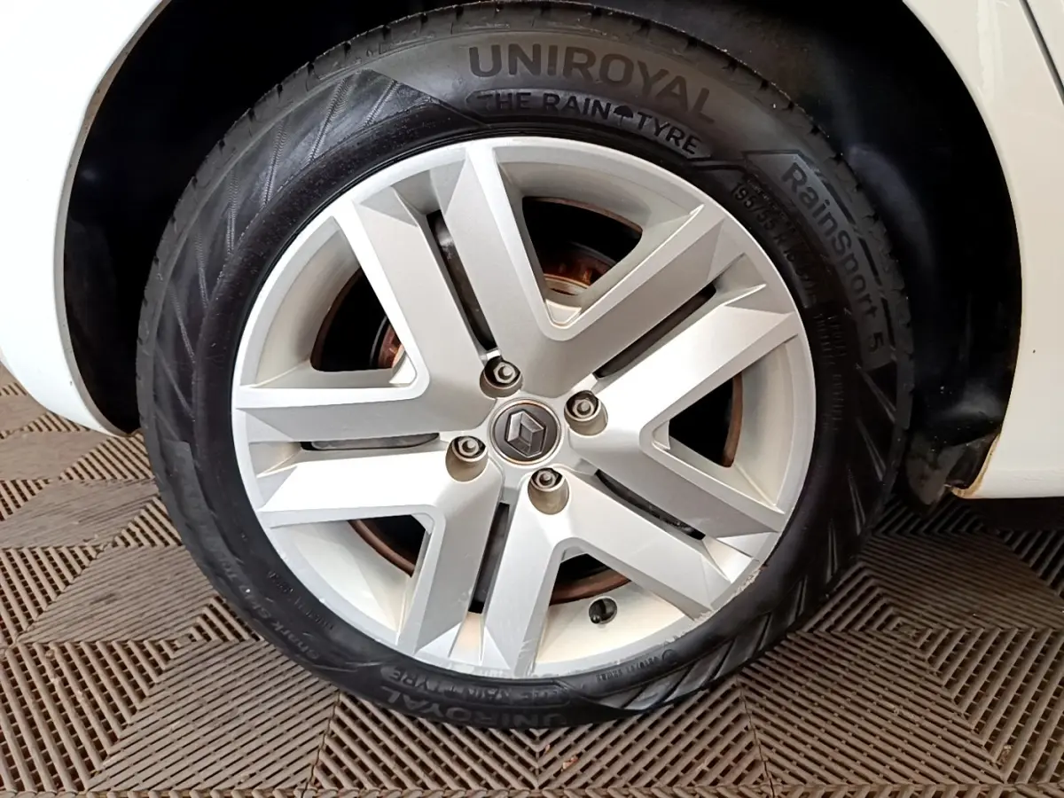 Gros plan sur la roue avant droite blanche d'une Renault Clio Business Blue dCi 85 avec jante alliage moderne.