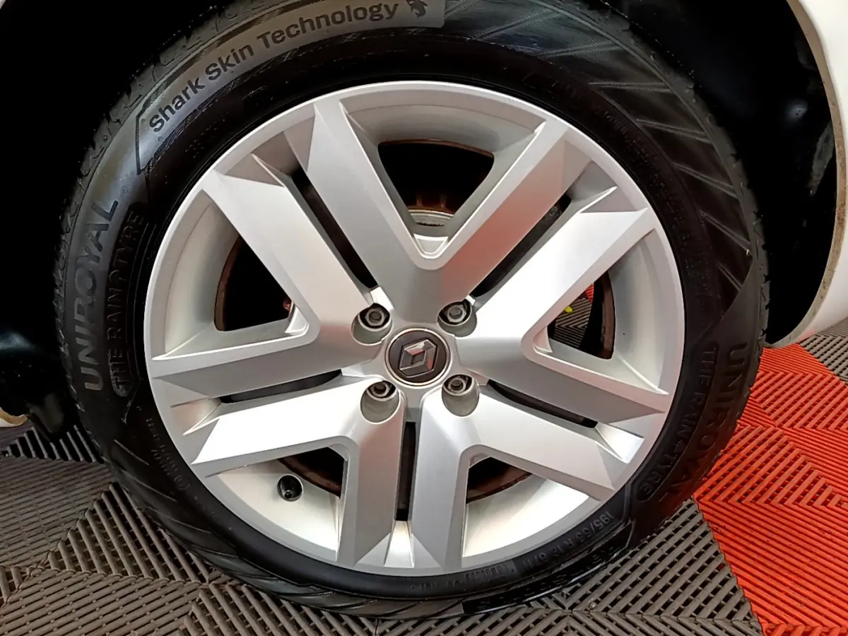 Gros plan sur la roue avant droite blanche d'une Renault Clio Business Blue dCi 85 avec jante alliage moderne.