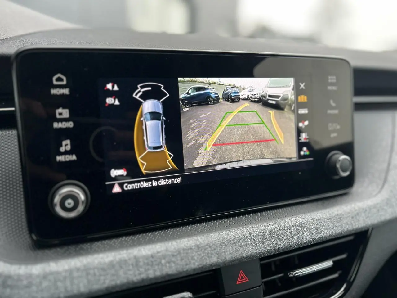 Écran central du Skoda Kamiq noir Magic montrant la caméra de recul avec guidage de trajectoire et alertes de proximité.
