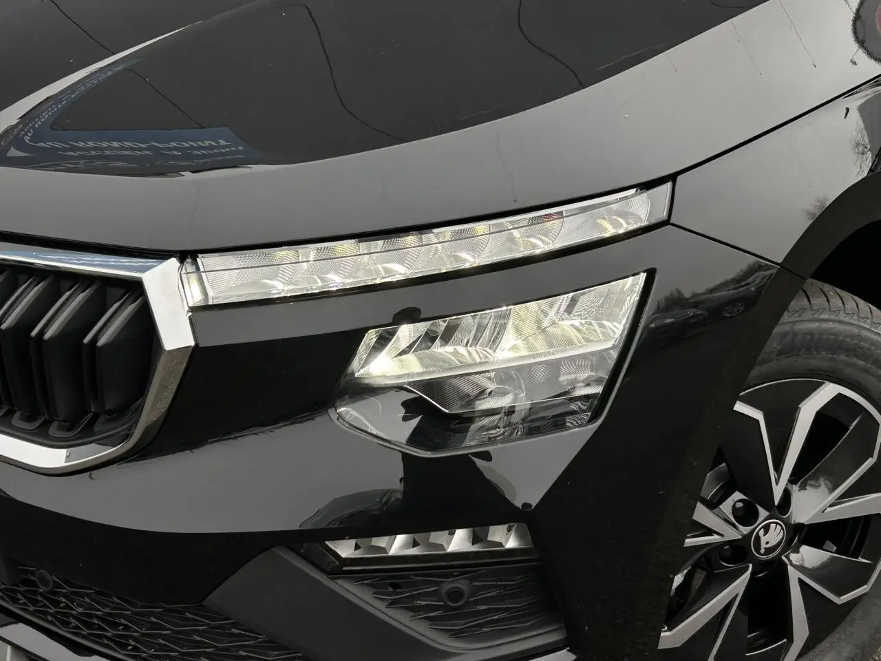 Gros plan sur l'avant droit noir Magic du Skoda Kamiq 2025, mettant en valeur les phares Full LED et la jante alliage.