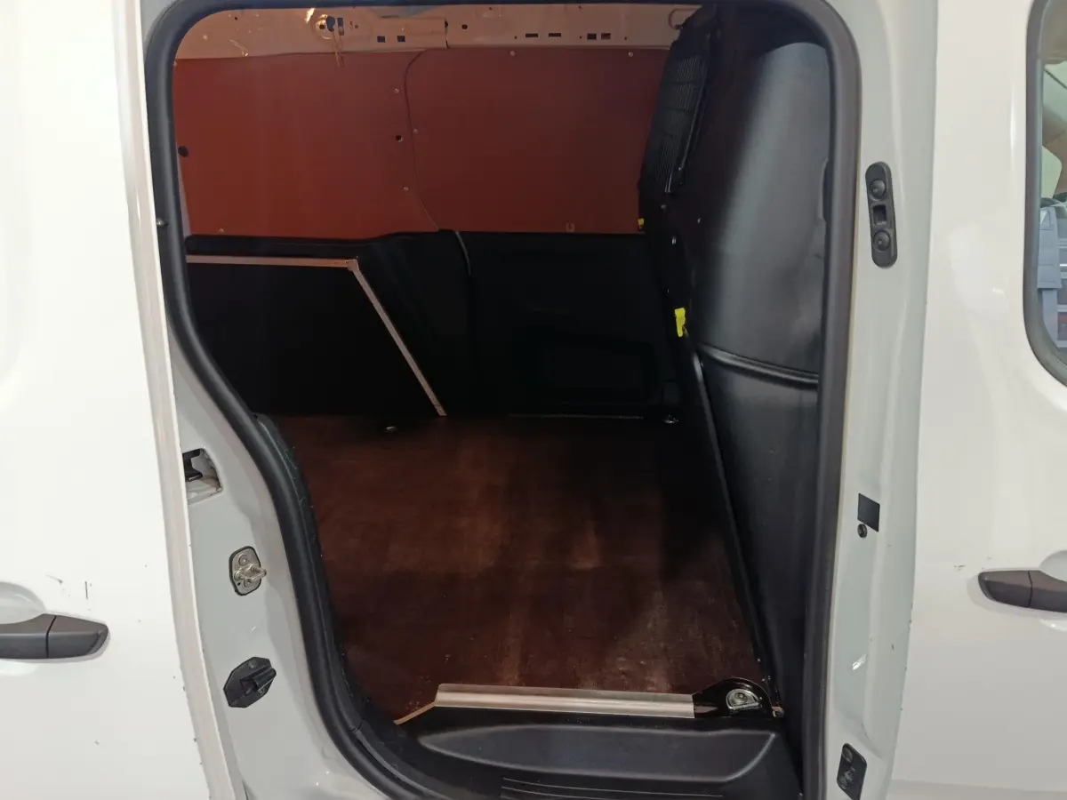Vue intérieure de la zone de chargement du Citroën Berlingo blanc avec cloison pleine et plancher en bois.