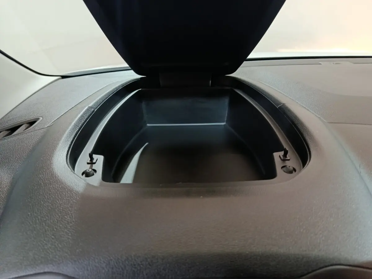 Vue rapprochée du compartiment de rangement ouvert sur le tableau de bord noir du Citroën Berlingo blanc 2021.