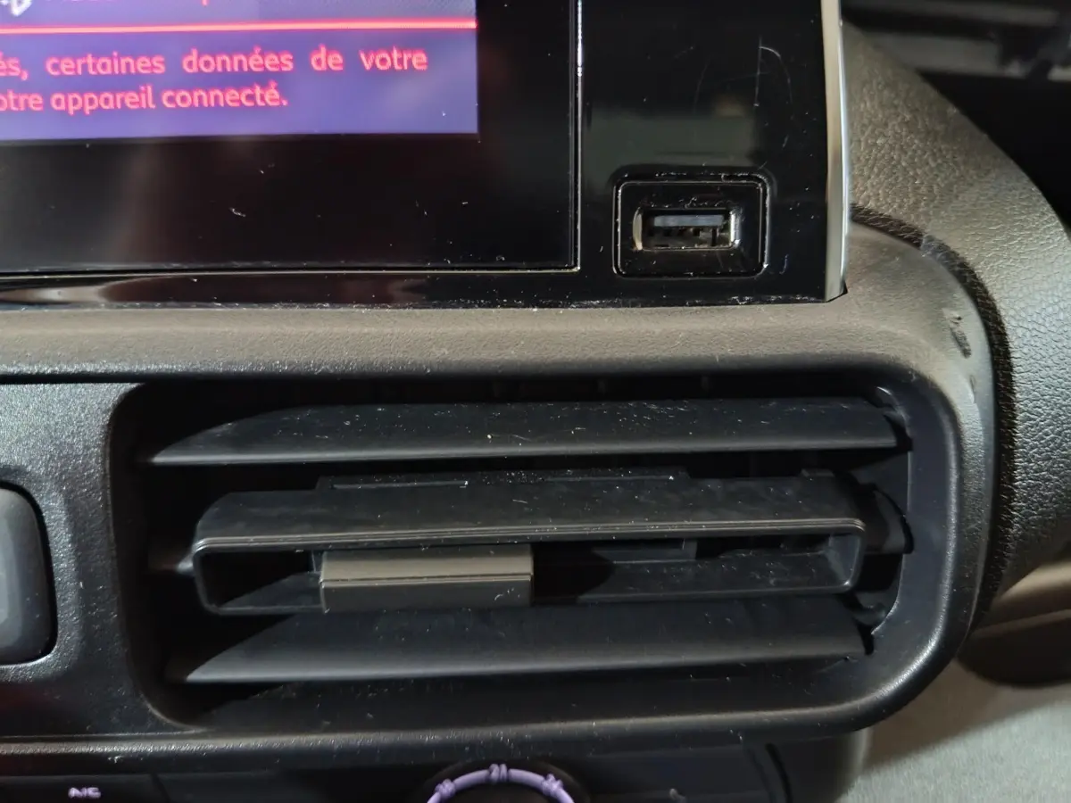 Gros plan sur la sortie d'air et port USB du tableau de bord du Citroën Berlingo blanc, version 2021.