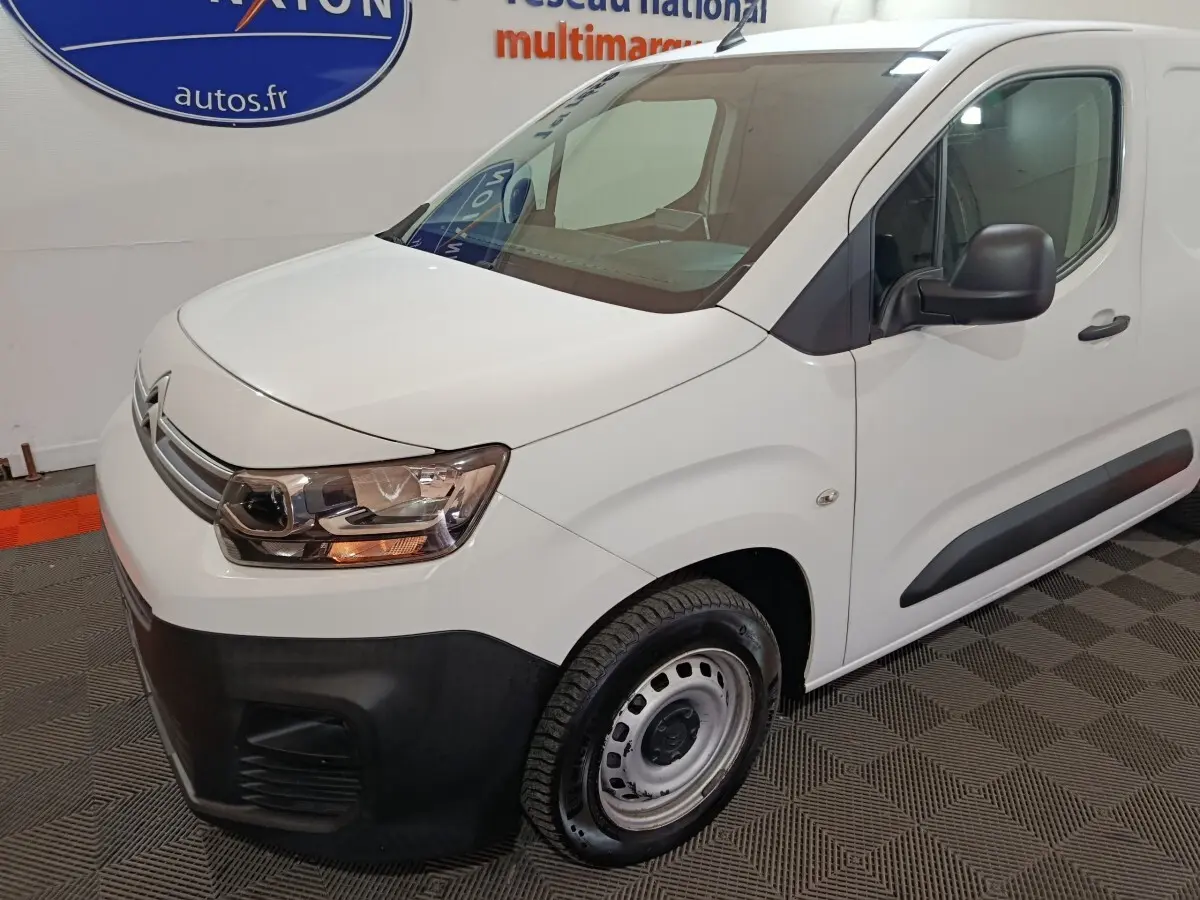 Vue 3/4 avant droit d'un utilitaire Citroën Berlingo blanc avec pare-chocs noir et jantes acier simples.