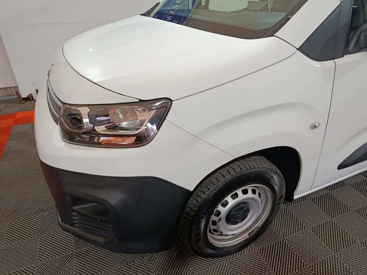 Gros plan sur l'avant droit du Citroën Berlingo blanc 2021, mettant en valeur le phare et la roue acier nue.