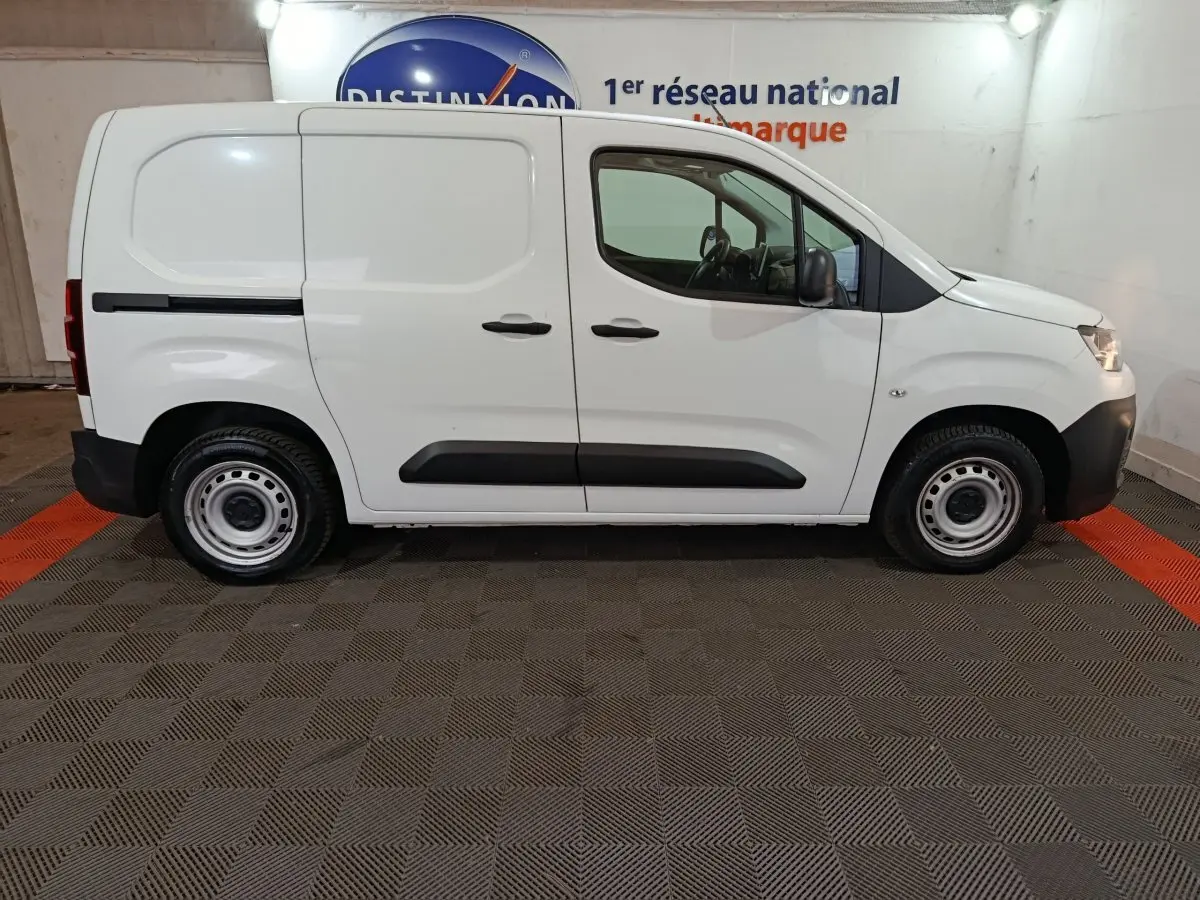 Profil côté droit d'un utilitaire blanc Citroën Berlingo 2021 avec portes latérales pleines et jantes acier.