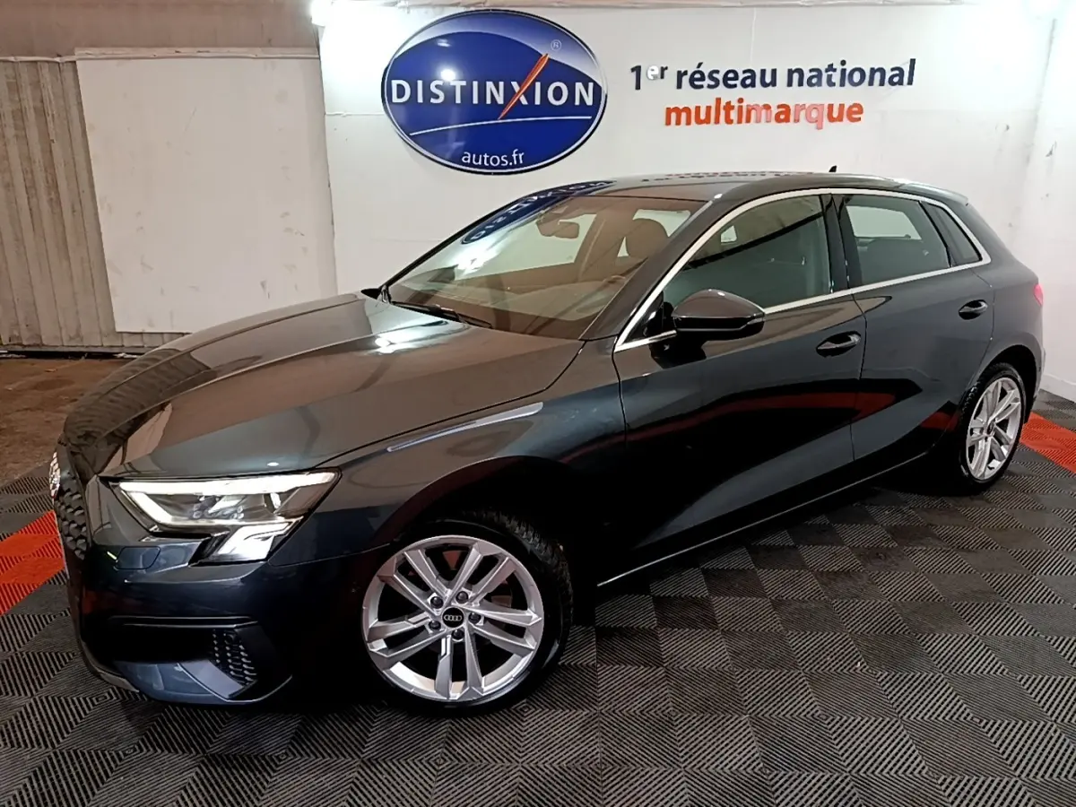 Audi A3 35 TFSI gris foncé vue 3/4 avant droit, avec jantes alliage et phares LED allumés.